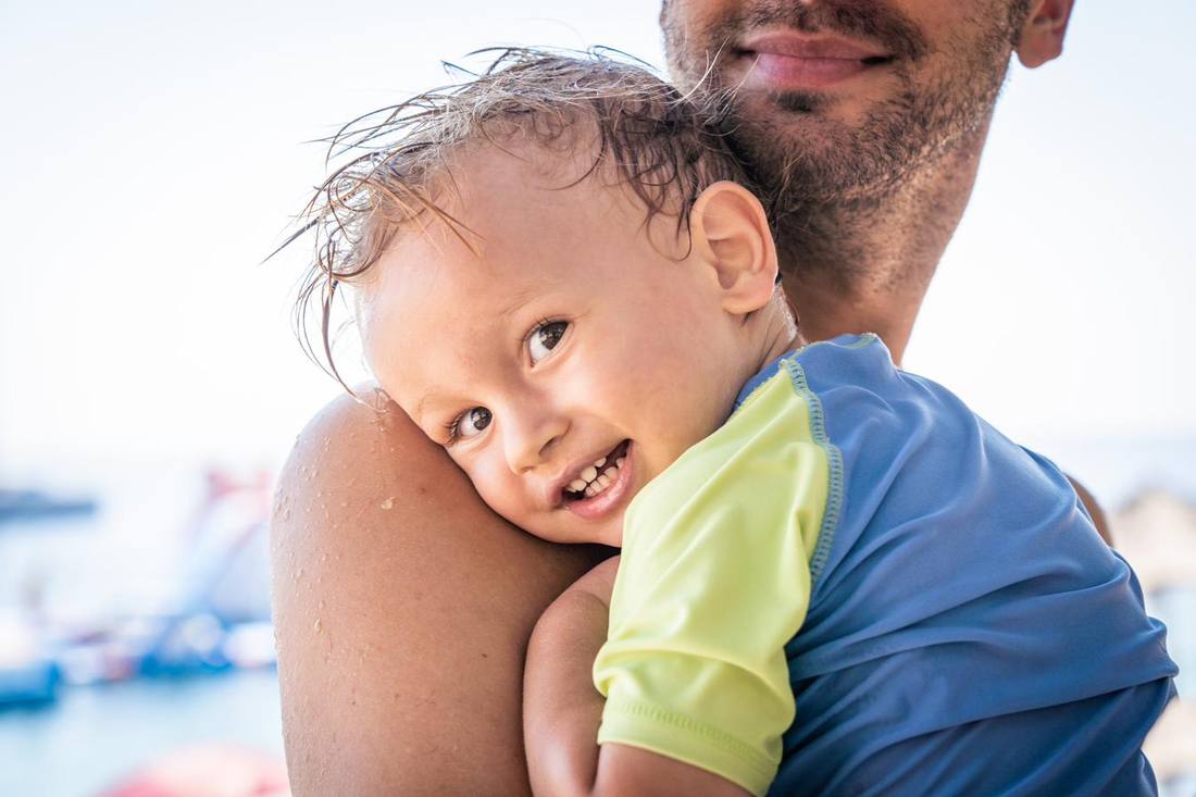 Vater trägt sein Kind am Meer